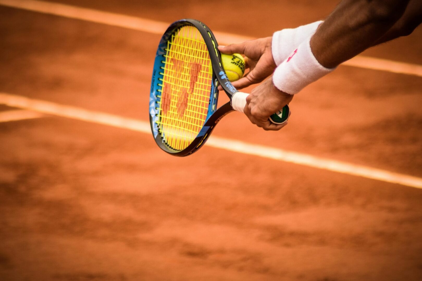 Tennis racket and ball on clay surface