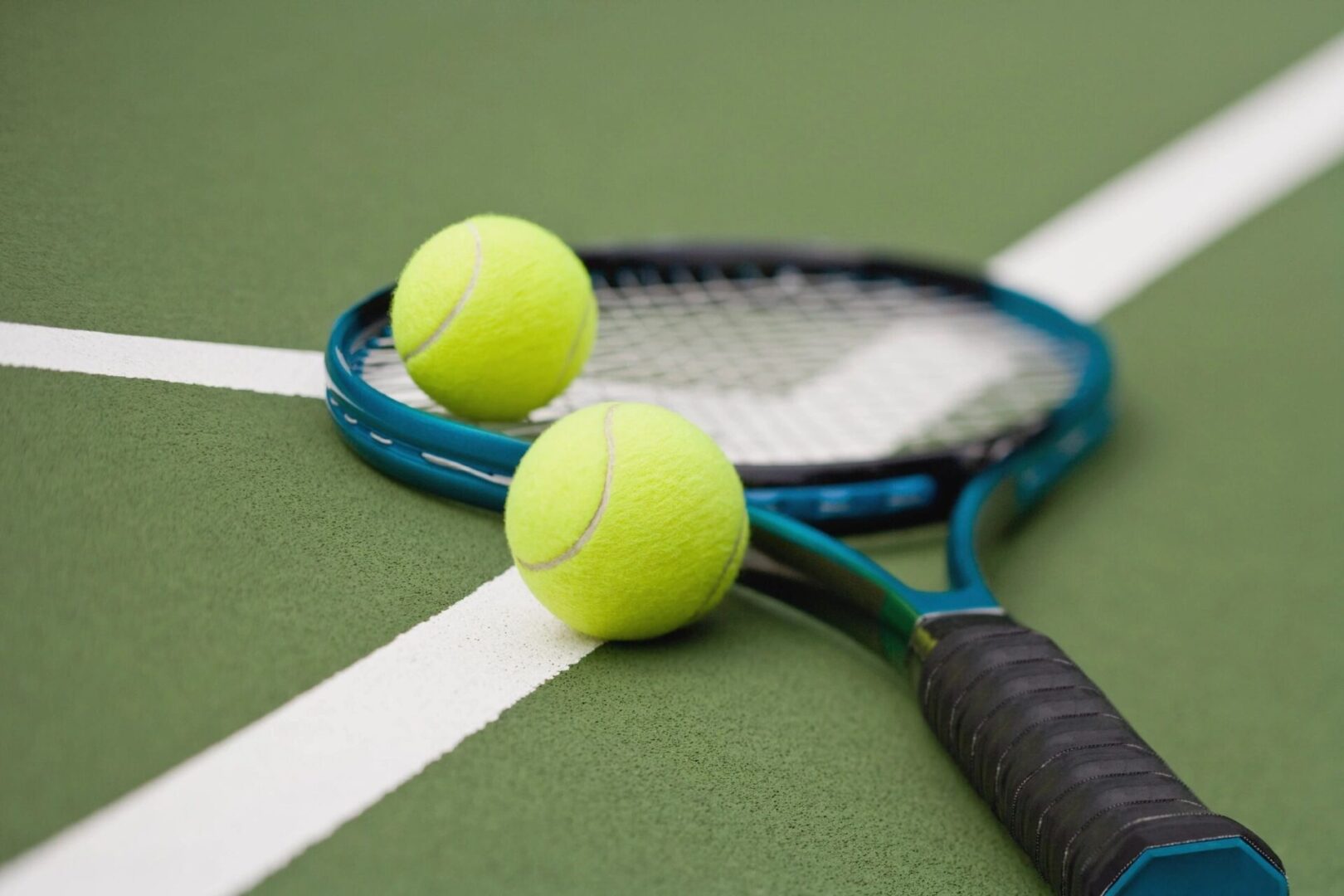 Tennis racket and balls on court